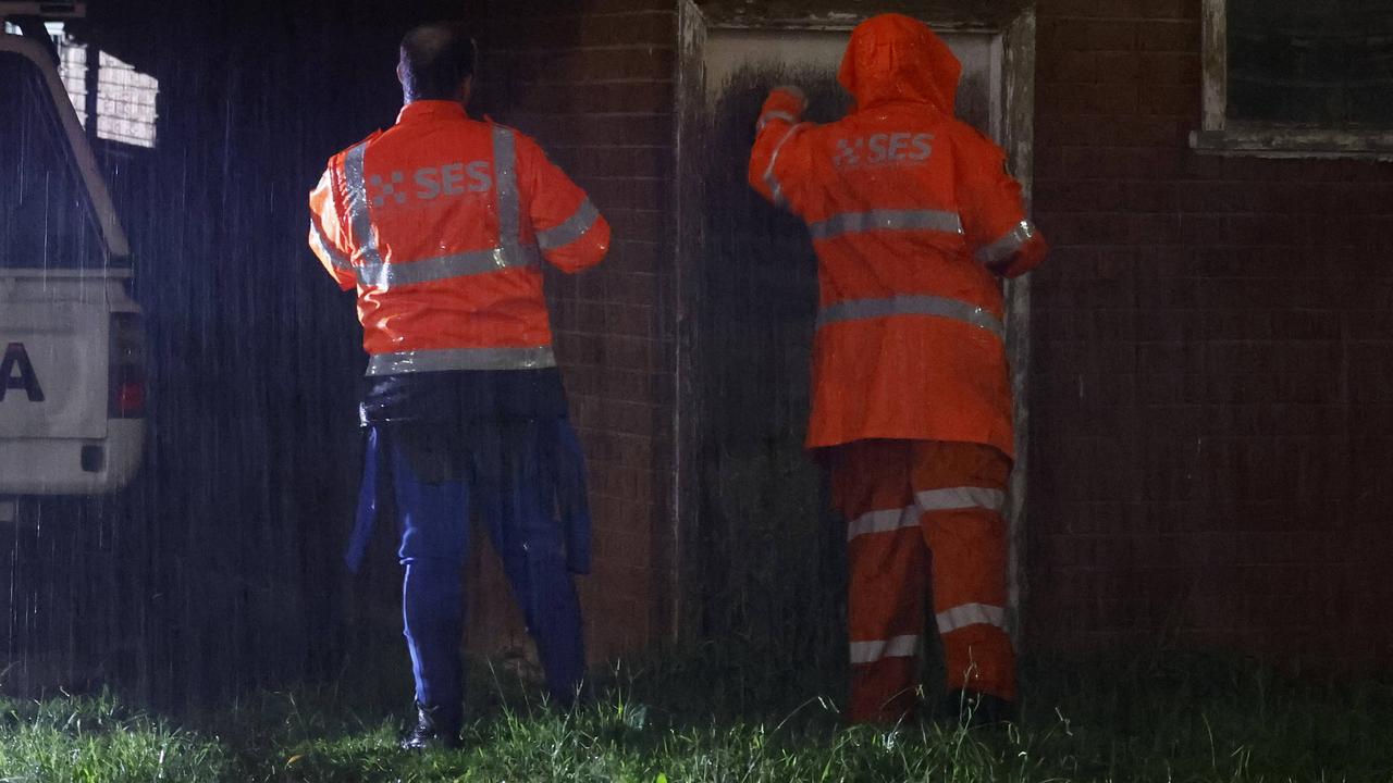 SES volunteers went doorknocking in the driving rain to warn residents about the order to evacuate. Picture: Jonathan Ng