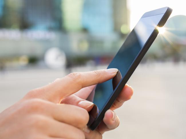 Businesswoman using her mobile phone in front of Building