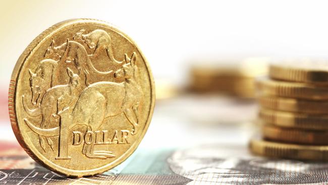 Generic photo of an Australian dollar coin .. Aussie one dollar coins, on a twenty dollar note.