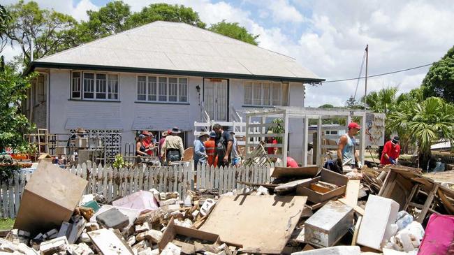 HELPING HAND: Volunteers combine to clean out this Gavin St home in North Bundaberg, one of many inundated by floodwaters. Picture: Carolyn Archer BUN050213MUD6