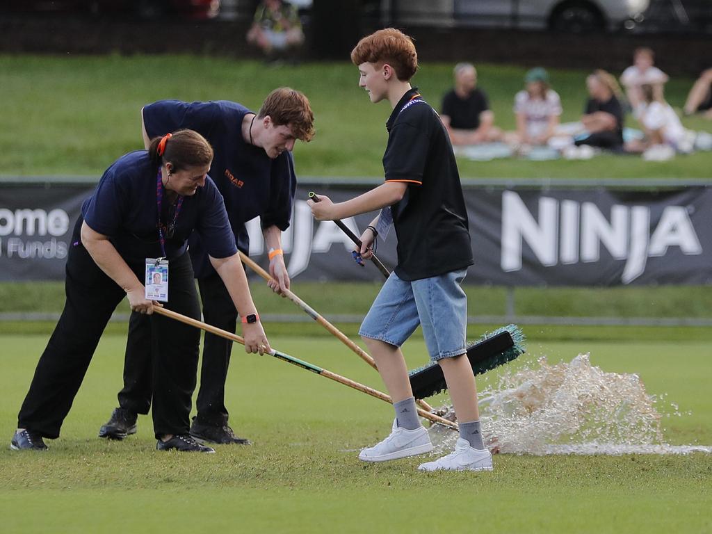 Volunteer ground staff try to clear water from the ground. Picture: Regi Varghese/Getty Images