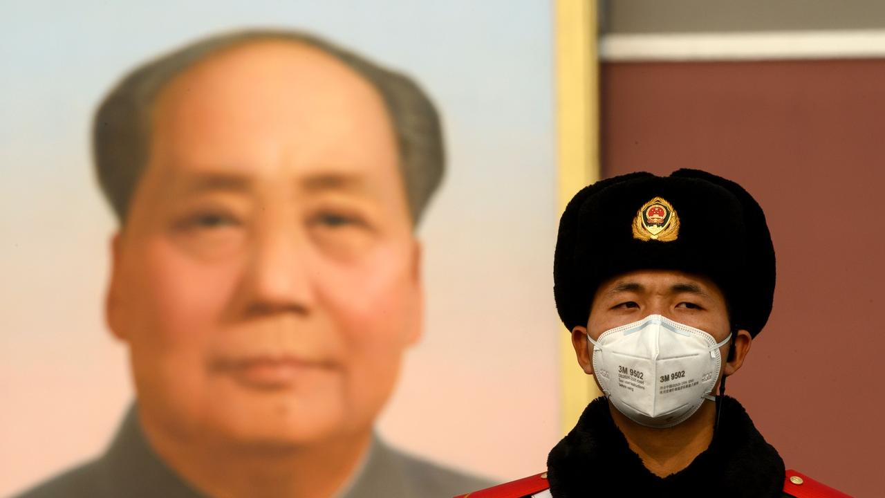 A paramilitary police officer wearing a protective facemasks to help stop the spread of a deadly SARS-like virus which originated in the central city of Wuhan, stand on guard in front of the portrait of late communist leader Mao Zedong at Tiananmen Gate in Beijing. Picture: AFP