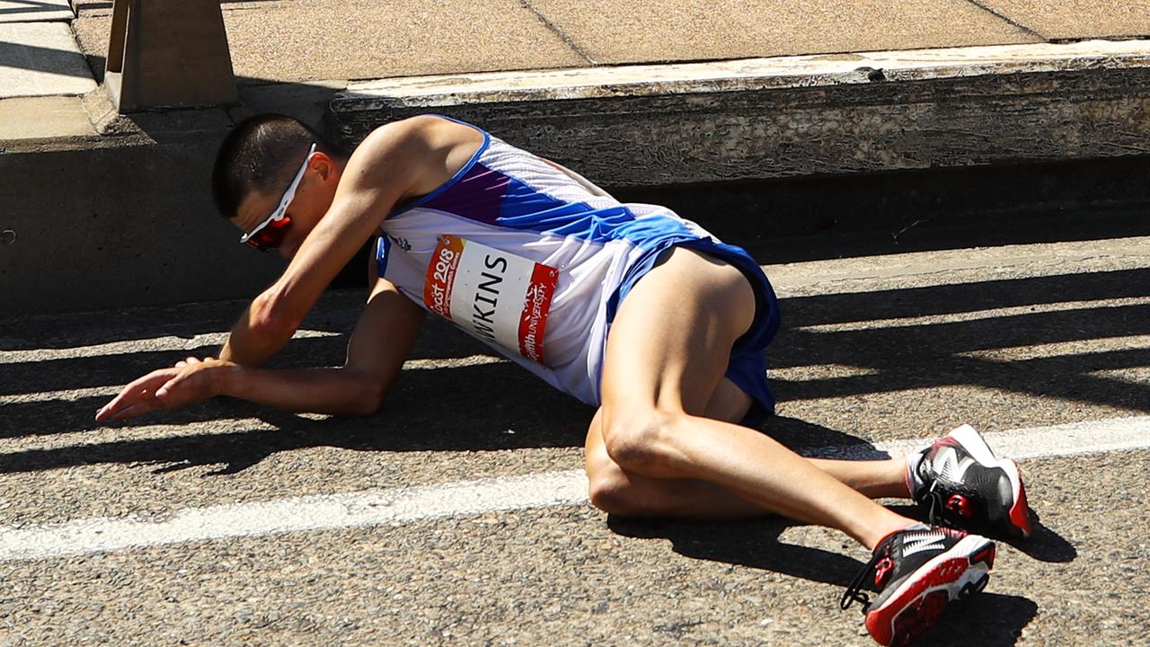 Callum Hawkins falls to the ground during the marathon on the Gold Coast.