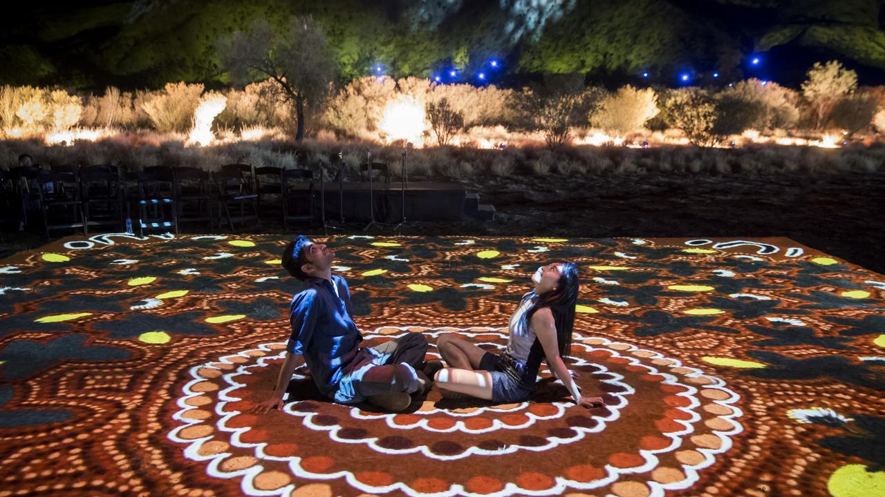 Visitors interact with one of the art installations at Parrtjima.Parrtjima takes place in Alice Springs with light installations from a number aboriginal artists set against the majestic MacDonnell Ranges.