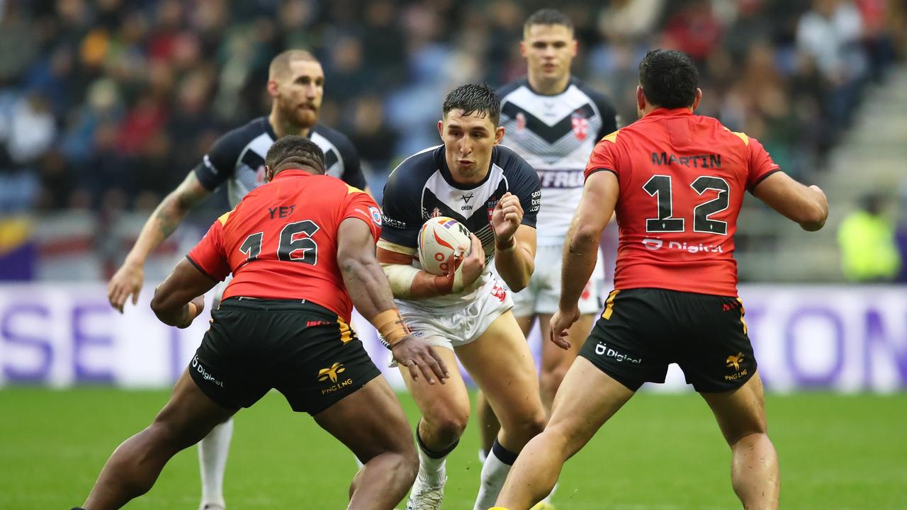 WIGAN, ENGLAND - NOVEMBER 05: Victor Radley of England looks to break past Mackenzie Yei and Rhyse Martin of Papua New Guinea during Rugby League World Cup Quarter Final match between England and Papua New Guinea at DW Stadium on November 05, 2022 in Wigan, England. (Photo by Jan Kruger/Getty Images for RLWC)