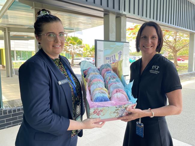 QPS Community Correctionsâ&#128;&#153; Krysten Butcher gifted 68 hand knit beanies to Mackay Base Hospitalâ&#128;&#153;s Kristi Algate. Photo: Zoe Devenport