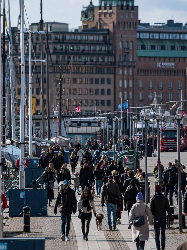 People walk at Strandvagen in Stockholm on April 4.