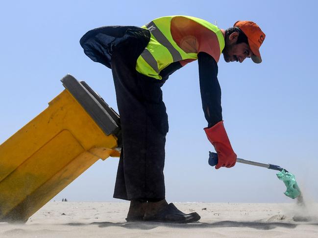 TOPSHOT - A worker of Cantonment Board Clifton (CBC) collects plastic and other waste from the Clifton beach in Karachi on September 19, 2019. (Photo by ASIF HASSAN / AFP)