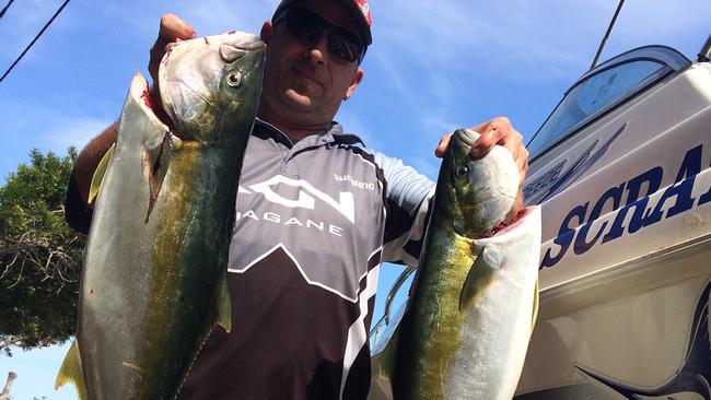 Port Stephens recreational fisherman Jeff Thompson with his catch of escaped farmed yellowtail kingfish.