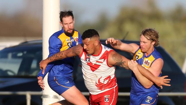 Avenel’s Hayden Heta battles with two Shepparton Swans opponents Thomas Campbell and Brendan Scott. Picture Yuri Kouzmin