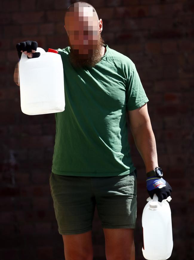 An inmate uses water tanks as weights whist exercising in the yard at Long Bay. Picture: Sam Ruttyn