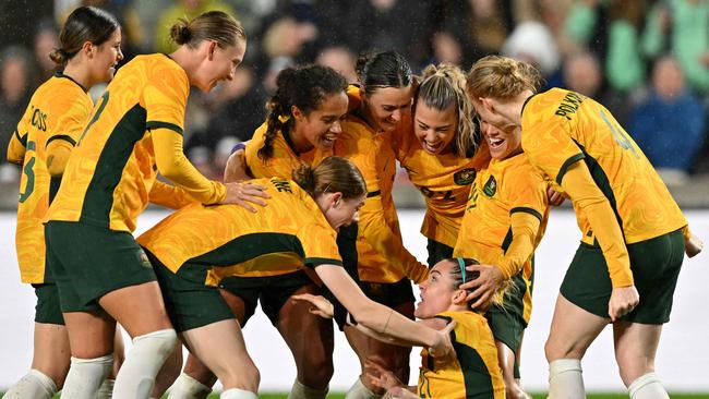 Defender Charlotte Grant (bottom) is mobbed by her Matildas teammates after scoring the second goal. Picture: AFP