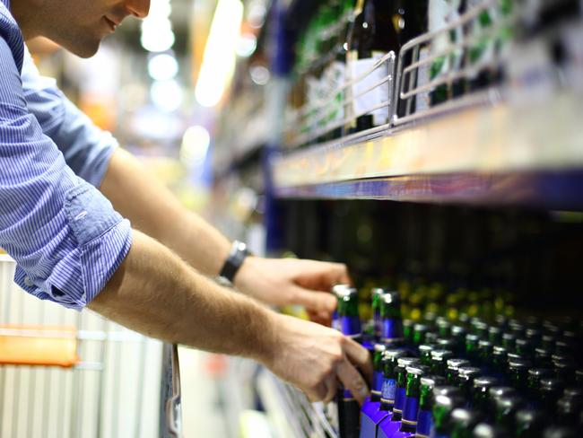 Man in supermarket buying beer.