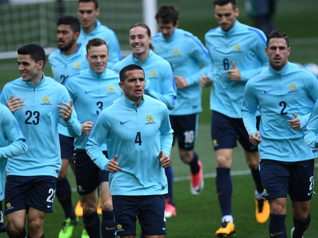 Tim Cahill (centre) leads the Socceroos as they jog laps during training.