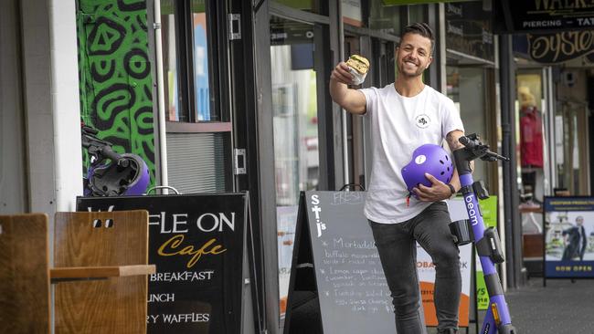 St. J's Deli owner Ben Korkmaz as part of the Beam e scooter trial at Hobart. Picture: Chris Kidd