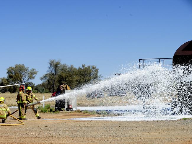 Firefighters conduct a fire drill using foam to quell the flames. Picture: Phil Williams