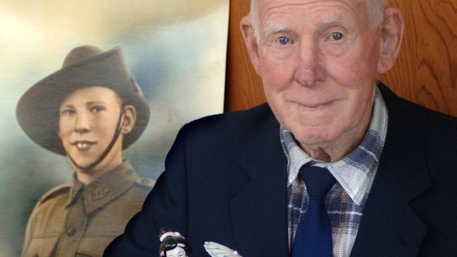 Allan Chick at his home in Heyfield with a 1940 portrait of himself taken when he was 20 years old.