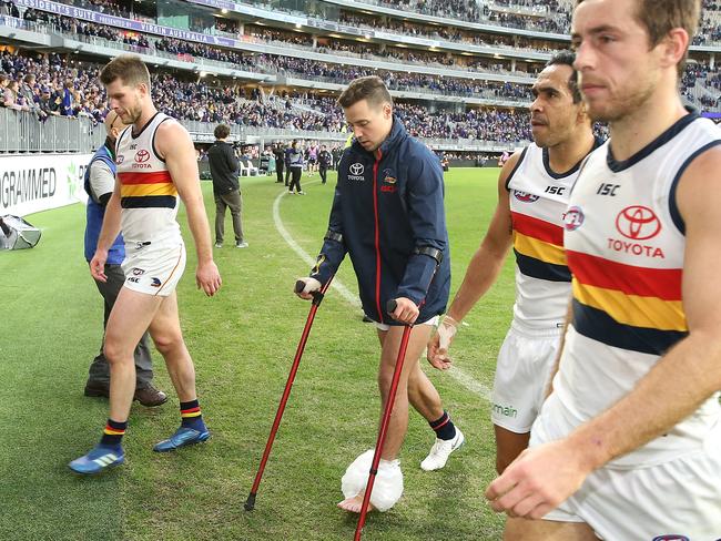 PERTH, AUSTRALIA - JUNE 10:  Luke Brown of the Crows leaves the field on crutches after being defeated during the round 12 AFL match between the Fremantle Dockers and the Adelaide Crows at Optus Stadium on June 10, 2018 in Perth, Australia.  (Photo by Paul Kane/Getty Images)