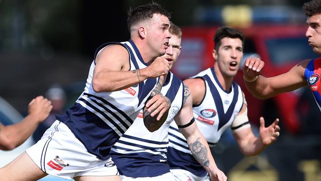 Kain Proctor fires out a handball for Bundoora. Picture: Steve Tanner