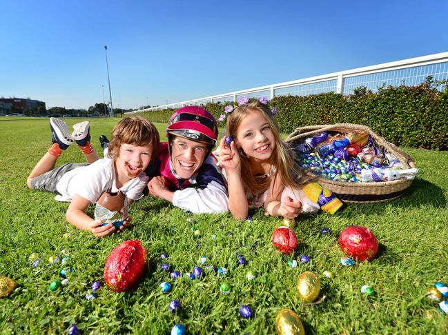 Celebrate Easter at Caulfield with the annual Easter egg hunt. Hugo, 5, jockey Chris Symons and Charli (7) with Easter eggs. Picture: Nicki Connolly