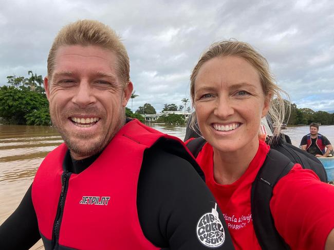 Mick Fanning gives Skye Swift a lift on his jet ski during the northern NSW floods