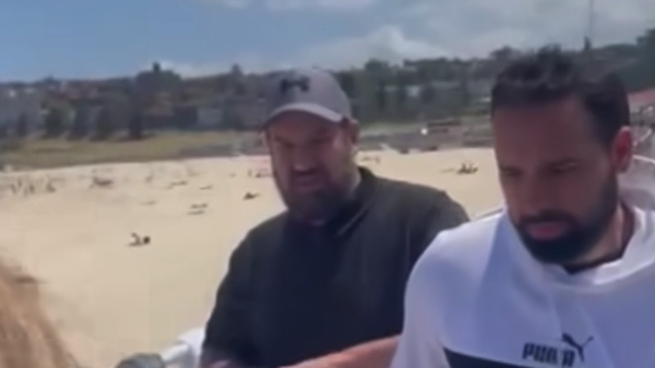 A video posted by the Australian Jewish Association appears to show two men who ripped down posters of kidnapped Israeli hostages at Bondi Beach on Thursday. Picture: Supplied.