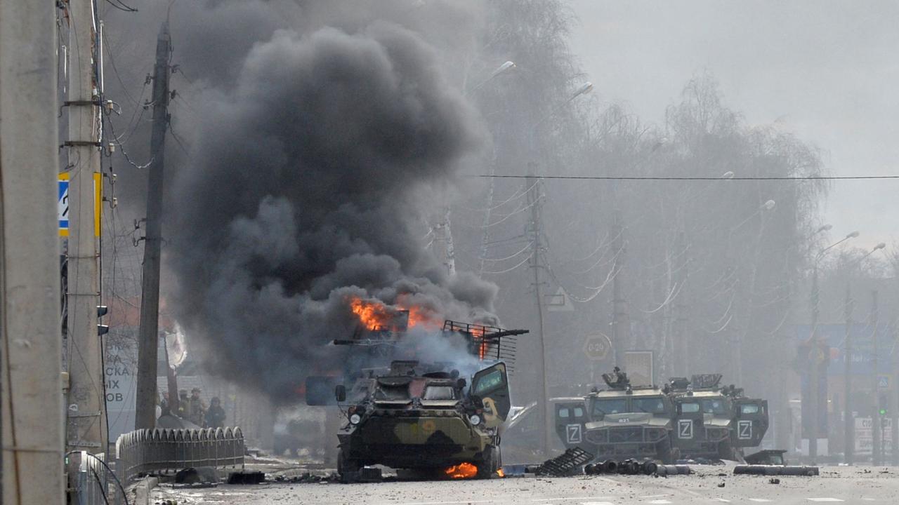 This photograph taken on February 26 shows a Russian Armoured personnel carrier burning during fight with the Ukrainian armed forces in Kharkiv. Picture: Sergey BOBOK/AFP