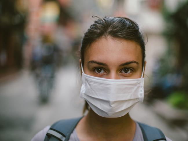 Young woman wearing face mask in the street.