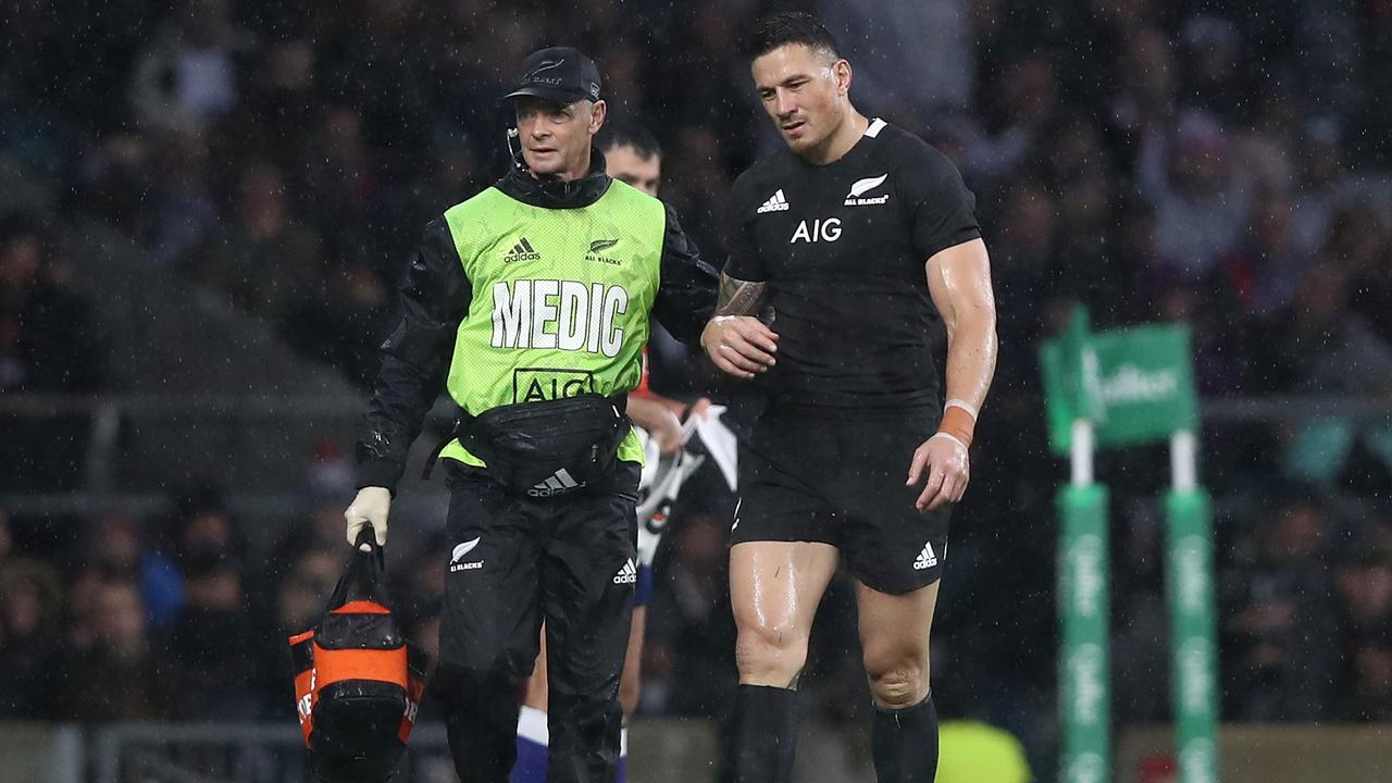 Sonny Bill Williams of the All Blacks leaves the pitch injured with doctor Tony Page.