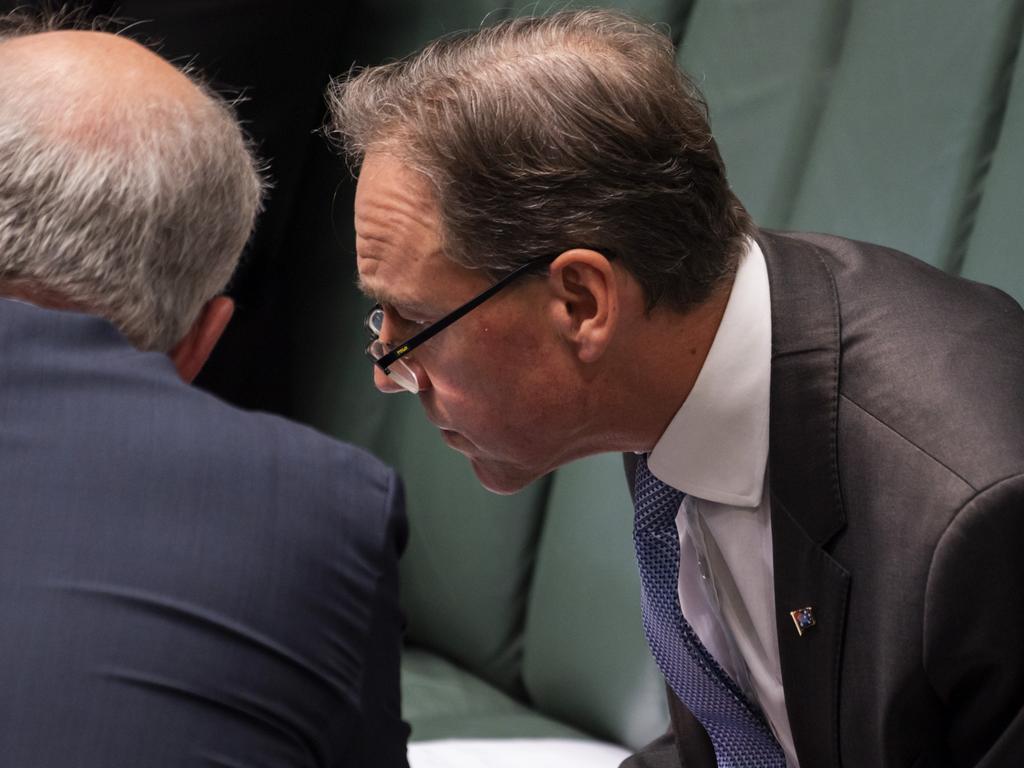 Health Minister Greg Hunt consults with Prime Minister Scott Morrison in the House of Representatives. Picture: NCA NewsWire/Martin Ollman