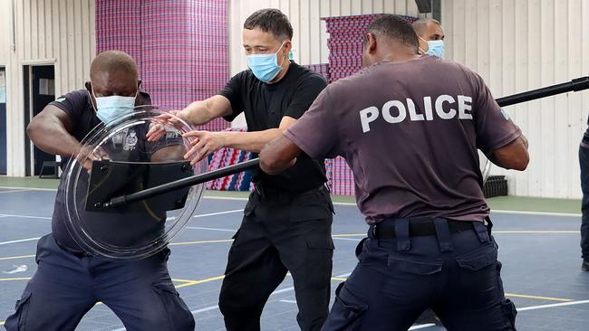 A China Police Liason Team officer (C) trains local Solomon Islands police officers in unarmed combat skills, tactical batons and rifle tactics. Picture AFP.