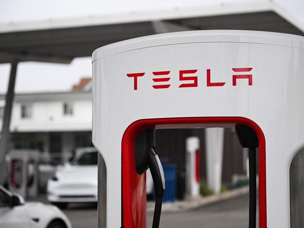 A charging handle is displayed on a charger stall at a Tesla Supercharger location. Picture: Patrick T. Fallon / AFP
