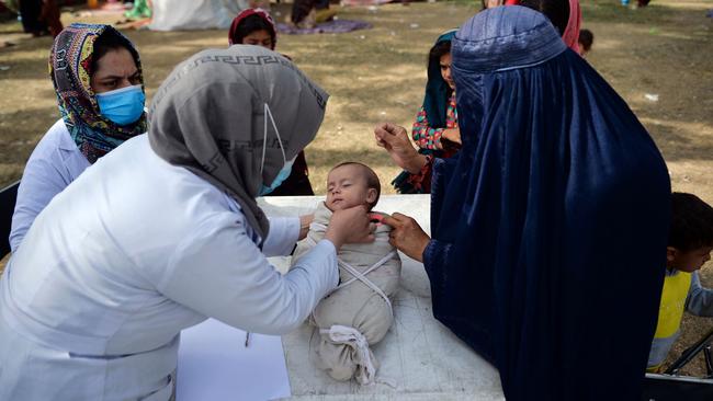 A health worker checks a child at a free medical camp for internally displaced people at Shahr-e-Naw Park in Kabul. Picture: AFP