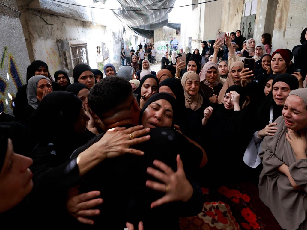 Palestinians mourn during a funeral of relatives, the morning after they were killed in an Israeli air strike.