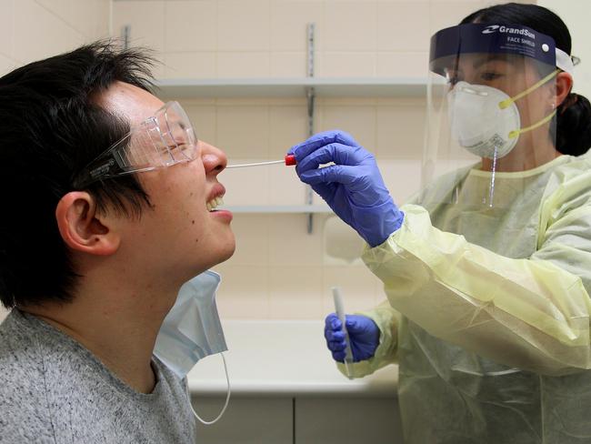 Registered nurse Sharan Coulter conducts a nasal swab test on Shi Yang Liu in the clinical assessment room at St George Hospital. Picture: Getty Images