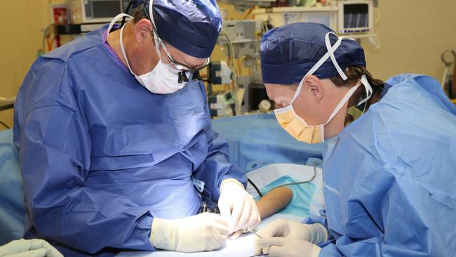 Dr Chris Jeffery (right) assisting orthopaedic surgeon Dr Greg Couzens in world first operation of world's smallest biomedical screw. Picture: Mandy Lake