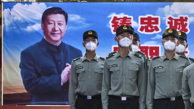 Chinese soldiers stand at attention in front of post of President Xi Jinping outside the Forbidden City, near Tiananmen Square, in Beijing, China. Picture: Getty Images