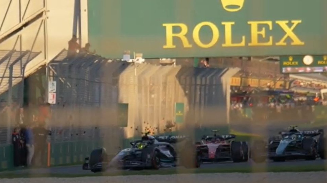 Fans can be seen huddling together as the Formula One cars speed past the unwelcome party. Picture: YouTube