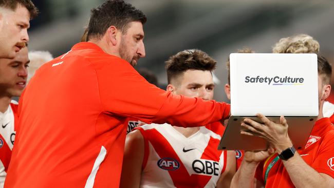 MELBOURNE, AUSTRALIA - JUNE 04: Dean Cox, Game Strategy & Ruck Coach of the Swans instructs players on a laptop during the 2022 AFL Round 12 match between the Melbourne Demons and the Sydney Swans at the Melbourne Cricket Ground on June 04, 2022 in Melbourne, Australia. (Photo by Michael Willson/AFL Photos via Getty Images)