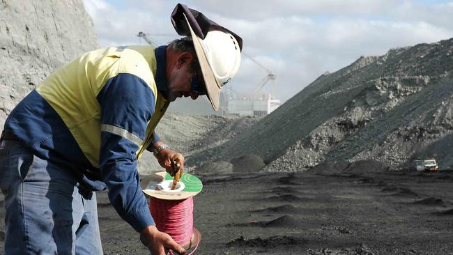 An Orica worker laying cable for a mining site blast.