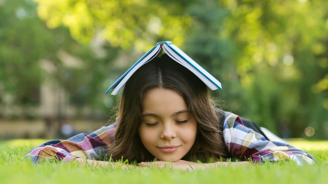 Calming book. Small child sleep on green grass. Bibliotherapy. Mindfulness and relaxation. Napping time. Back to school. Non-formal education and learning. Relaxing book for better sleep.