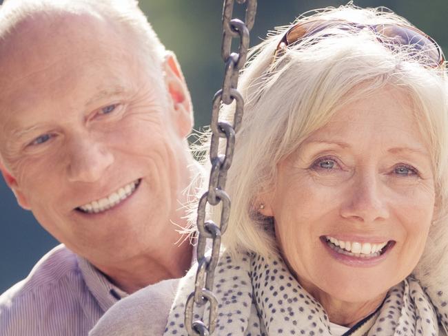 A playful and youthful senior couple, having fun at a playground.