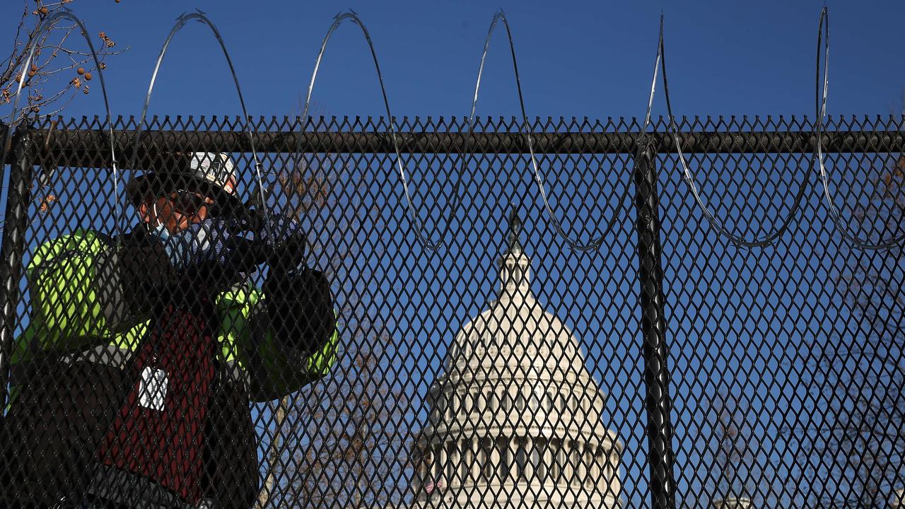 Workers put concertina razor wire along the top of the eight-foot ‘non-scalable’ fence that now surrounds the nation’s Capitol. Picture: Chip Somodevilla/Getty Images/AFP