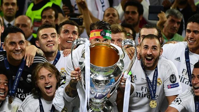 Real Madrid's Spanish defender Sergio Ramos (C) lifts the Champions League trophy.
