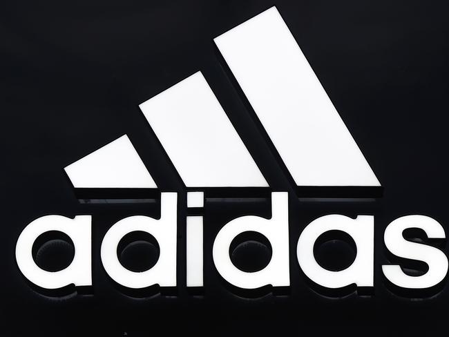 The logo of German sport brand Adidas is pictured on a store in Berlin on January 25, 2016. / AFP / TOBIAS SCHWARZ