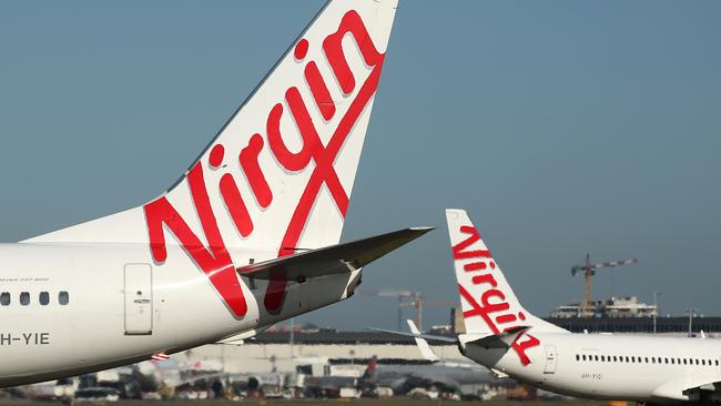 The Virgin Australia Holdings Ltd. logo is displayed on the tails of a Boeing Co. 737-800, left, and a Boeing Co. 737-8FE aircraft preparing to take off at Sydney Airport in Sydney, Australia, on Monday, Feb. 8, 2016. Virgin Australia is scheduled to announce half-year earnings on Feb. 11. Photographer: Brendon Thorne/Bloomberg