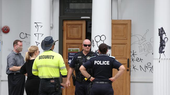 Police officers investigate the crime scene with council officers and a private security guard. Picture: Brendan Radke