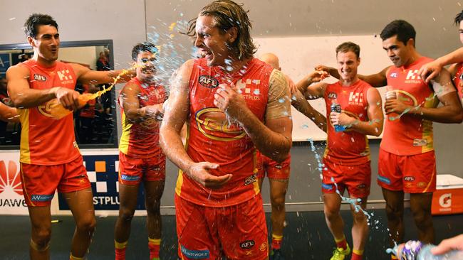 Brad Scheer is showered with drinks after Gold Coast’s win. Picture: AAP Images