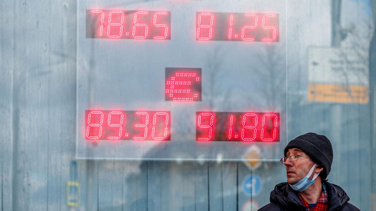 A man walks past a board showing currency exchange rates of the US dollar and the euro against Russian ruble in Moscow on February 22, 2022. Picture: Dimitar Dilkoff/AFP