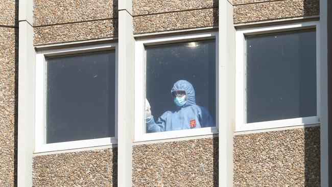 A cleaner sanitises a window at the Alfred Street housing tower. Picture: NCA NewsWire /David Crosling